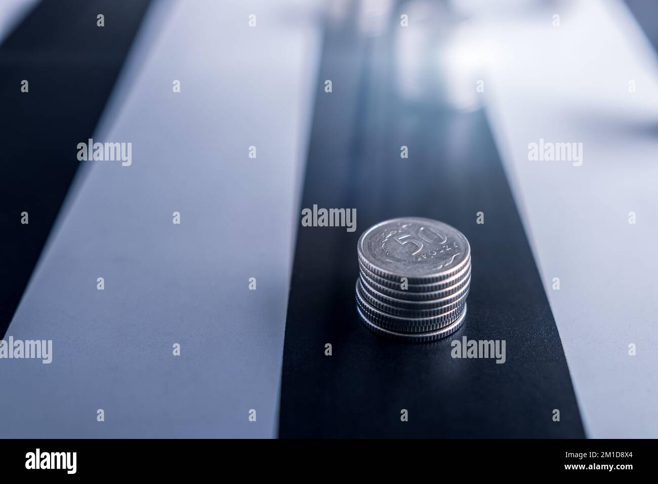 Monete polacche su un tavolo bianco e nero. Situazione finanziaria difficile. Riduzione dei risparmi Foto Stock