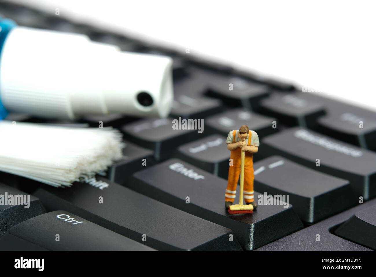 Fotografia di figura giocattolo delle persone in miniatura. Addetti alla pulizia della tastiera meccanica con scopa, spazzola e spruzzatrice. Isolato su sfondo bianco. Im Foto Stock