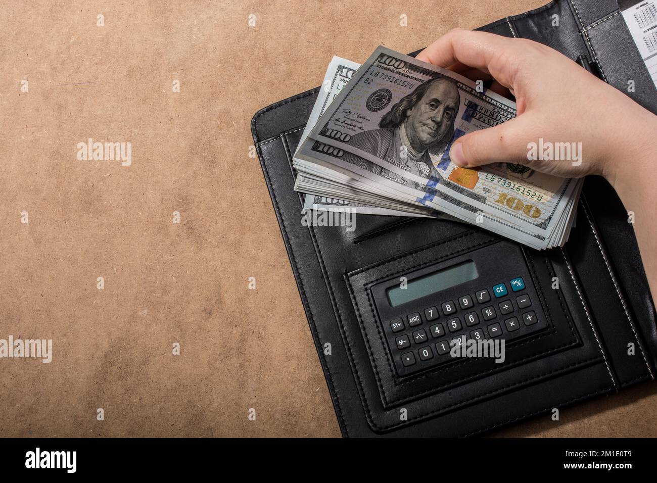 Mano azienda dollaro americano banconote accanto a una calcolatrice Foto Stock
