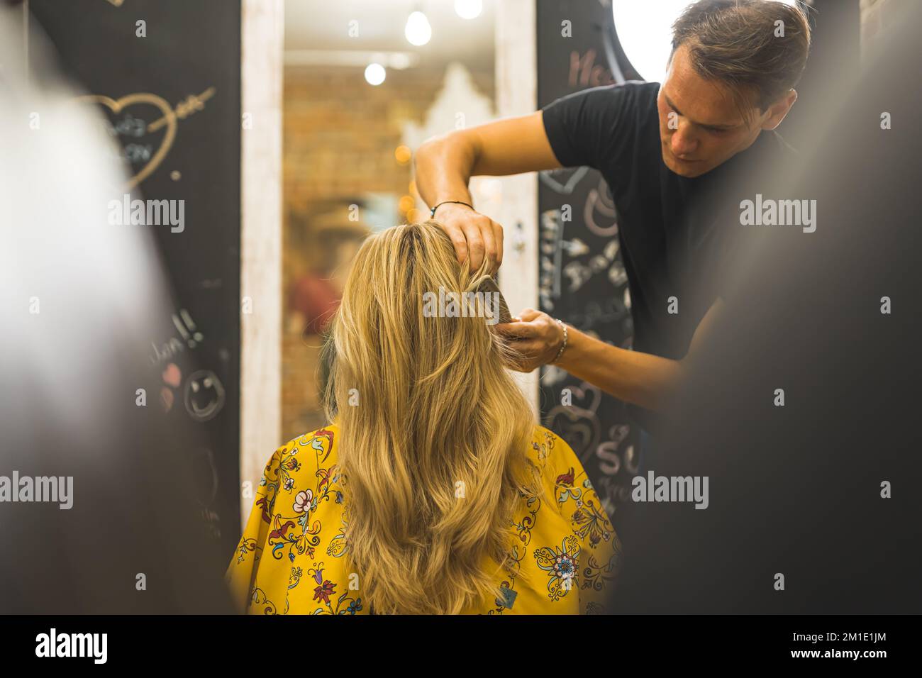 Parrucchiere styling capelli di una donna dopo il taglio dei capelli. Vista posteriore. Foto di alta qualità Foto Stock