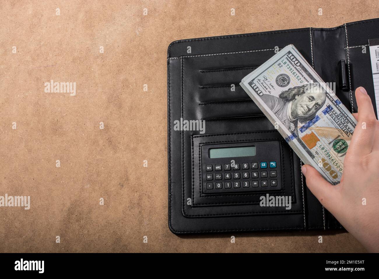 Mano azienda dollaro americano banconote accanto a una calcolatrice Foto Stock