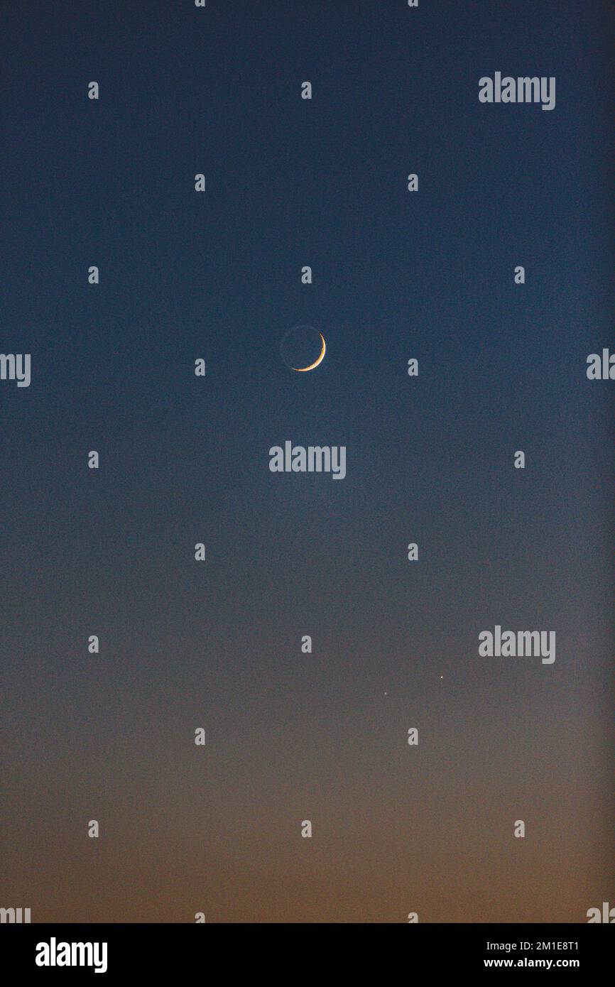 Uno scatto verticale della bella luna crescente nel cielo limpido di notte Foto Stock