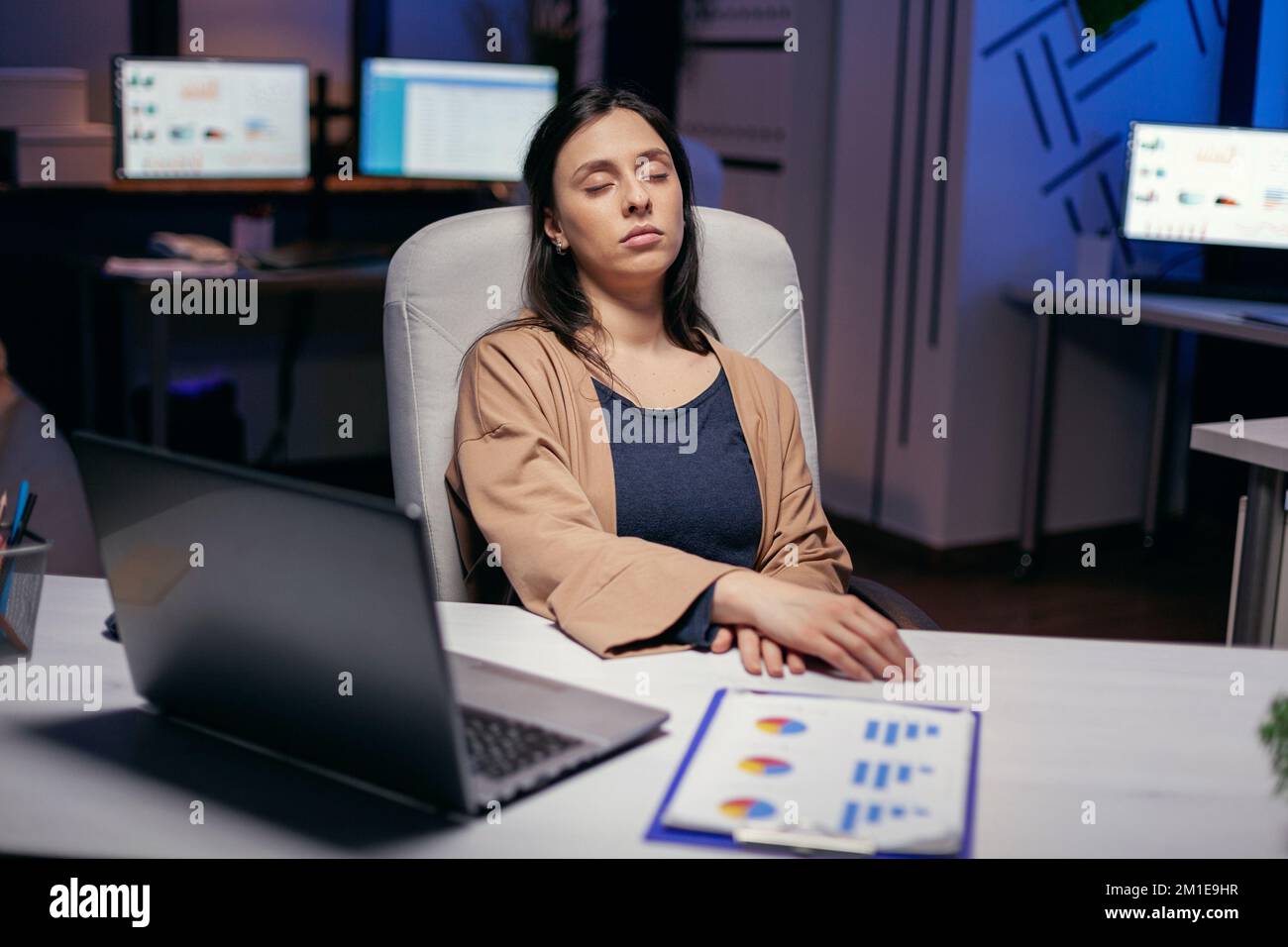 Freelance workaholic che dorme nel corso del progetto di scadenza in ufficio vuoto. I dipendenti si addormentano mentre lavorano solo di notte in ufficio per un importante progetto aziendale. Foto Stock