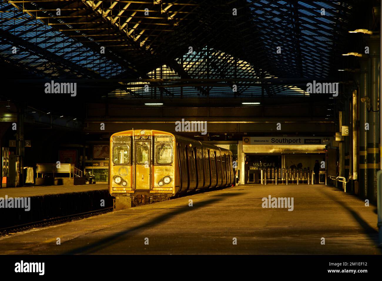 Stazione ferroviaria di Southport Terminus con il sole mattutino British Rail Classe 507 treno elettrico a più unità (EMU) passeggeri Foto Stock