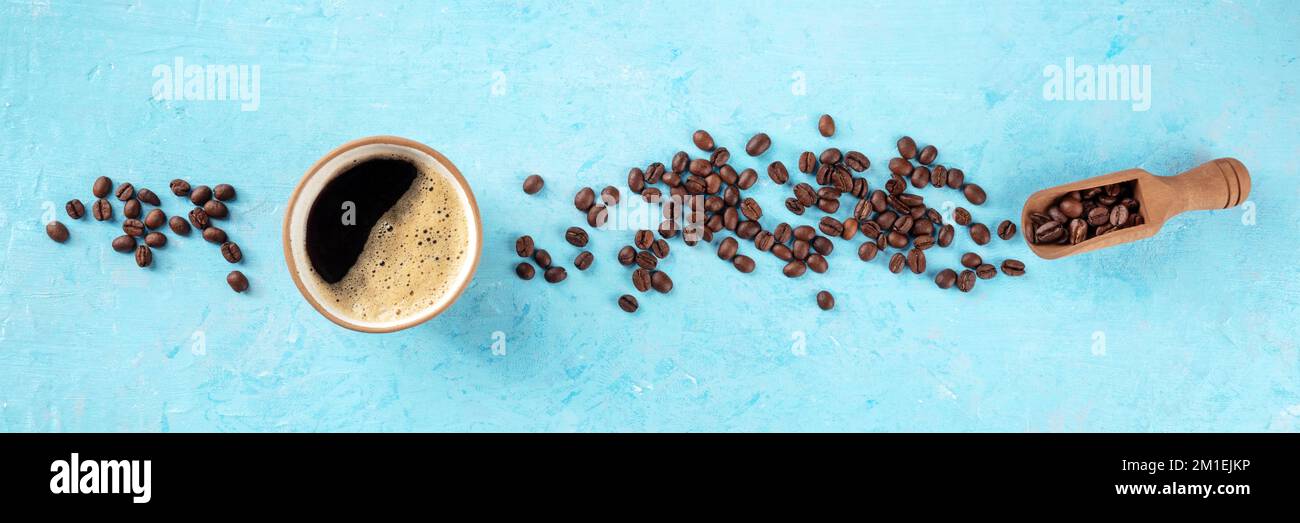 Tazza di caffè e chicchi panorama, piatto steso in testa girato su uno sfondo blu con spazio copia, un banner panoramico per un menu Foto Stock