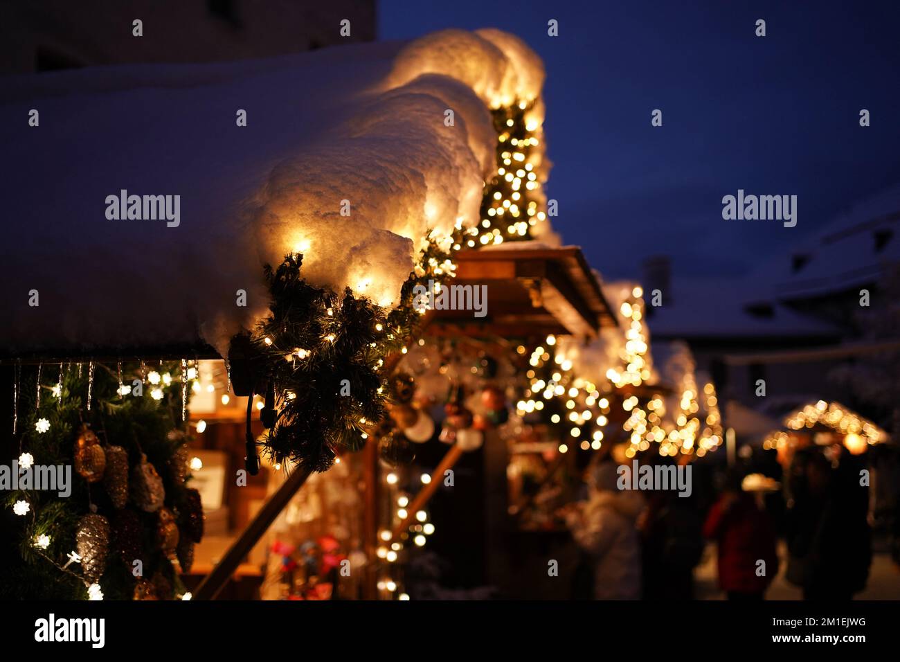 Primo piano di un mercato coperto di neve splendidamente illuminato e decorato in un mercatino di natale a Salisburgo, Austria. Foto Stock