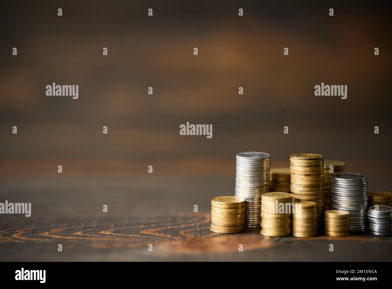 Pile di monete con spazio di copia per il testo su sfondo di legno. Concetto di finanza, banche e investimenti. Foto Stock
