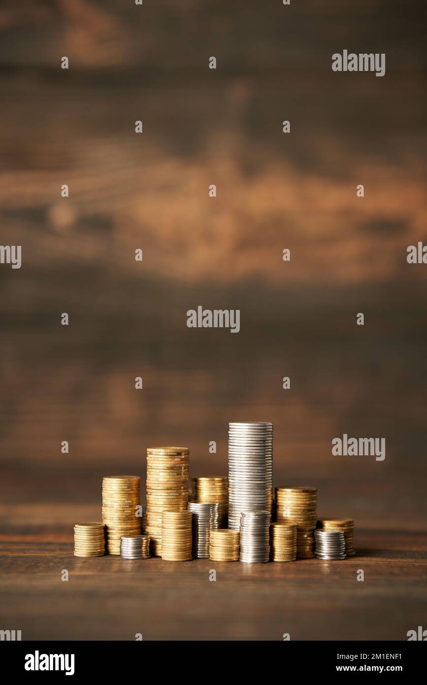 Pile di monete con spazio di copia per il testo su sfondo di legno. Concetto di finanza, banche e investimenti. Foto Stock