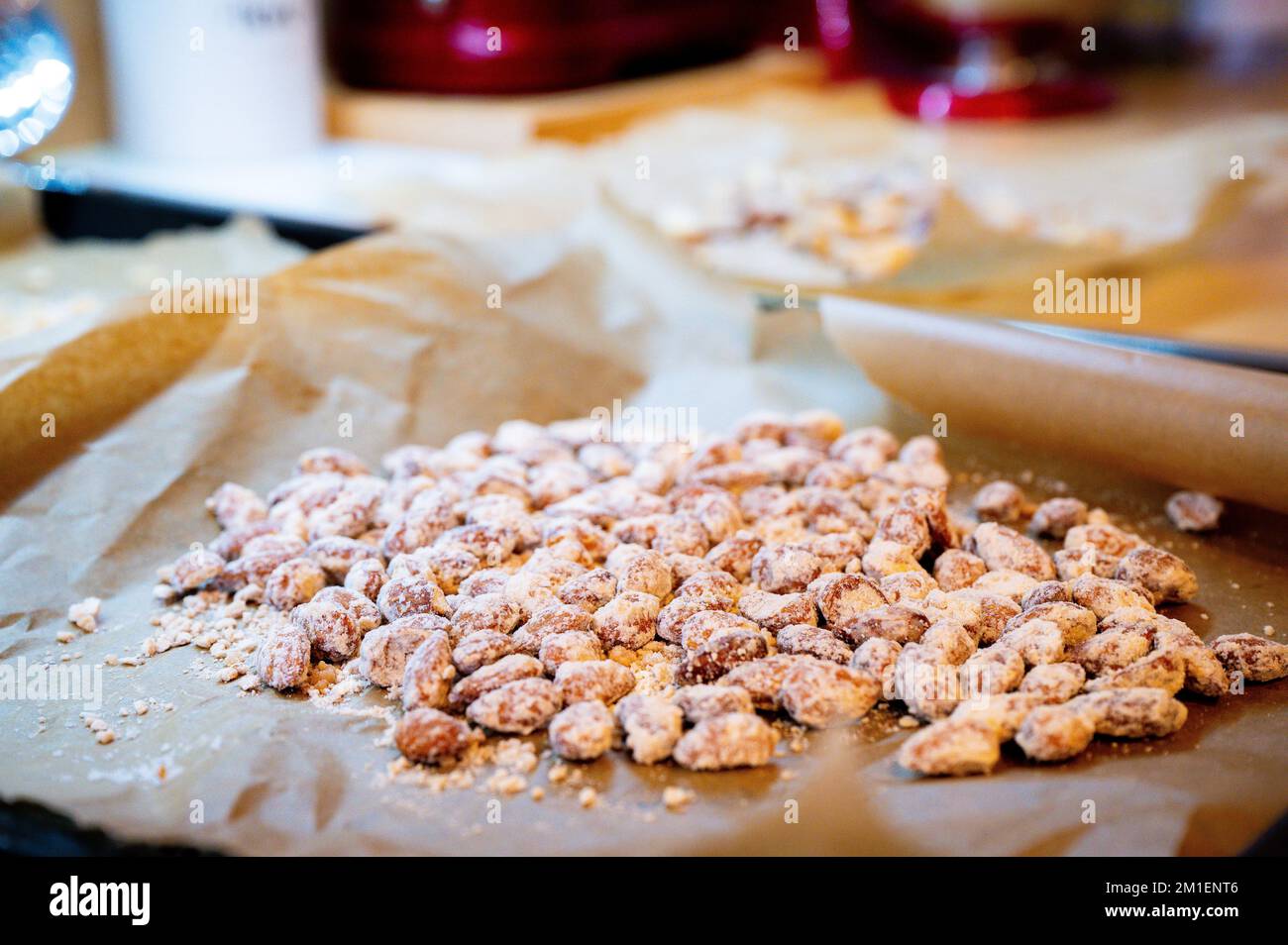 Deliziose mandorle tostate fatte in casa, candite e caramellate su carta da forno nella stagione natalizia. Foto Stock