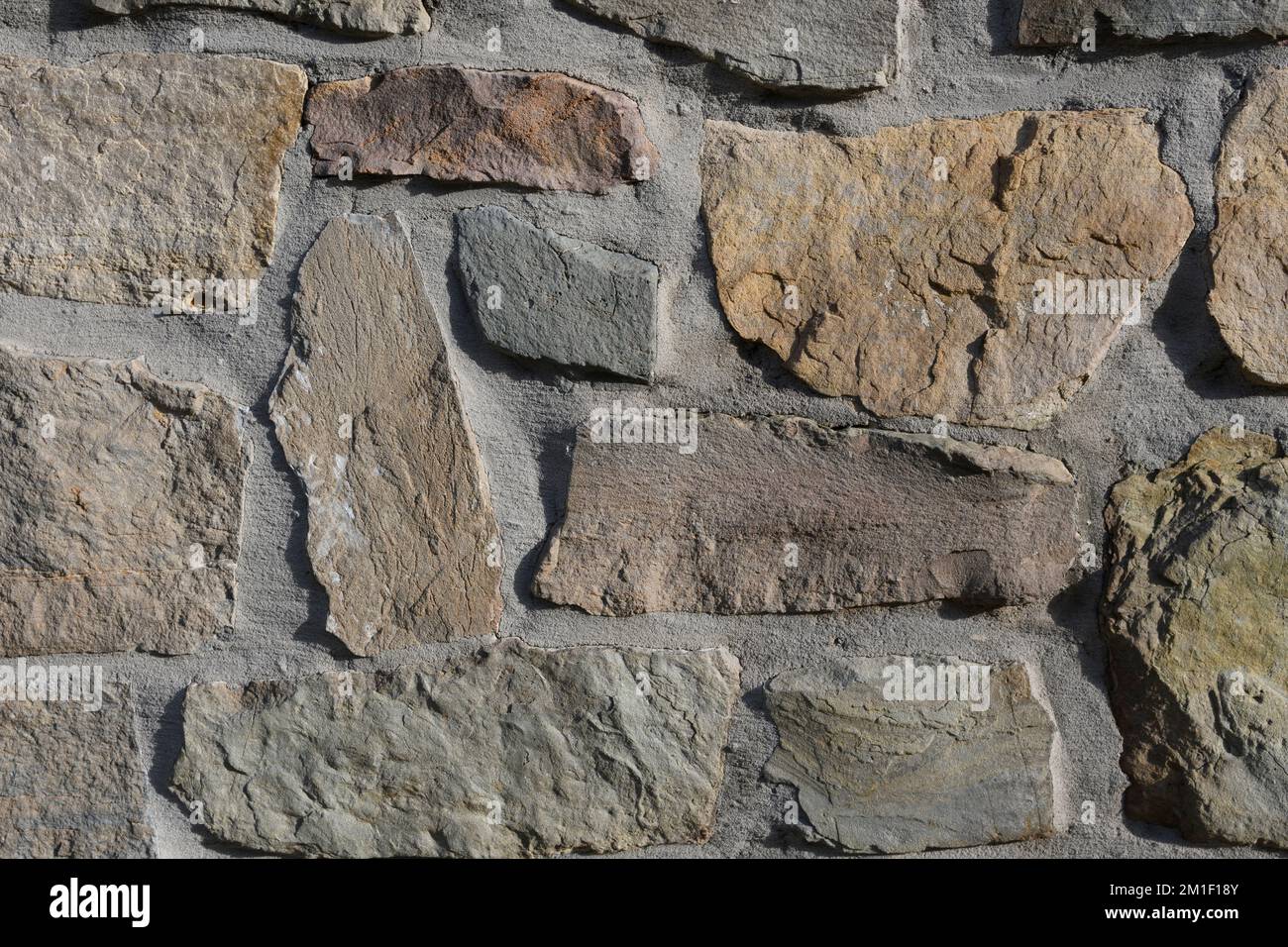Grandi pietre tagliate a mano in una disposizione libera. Tessitura di pietra vecchia. Pareti di marmo e pietra sfondo. Foto Stock