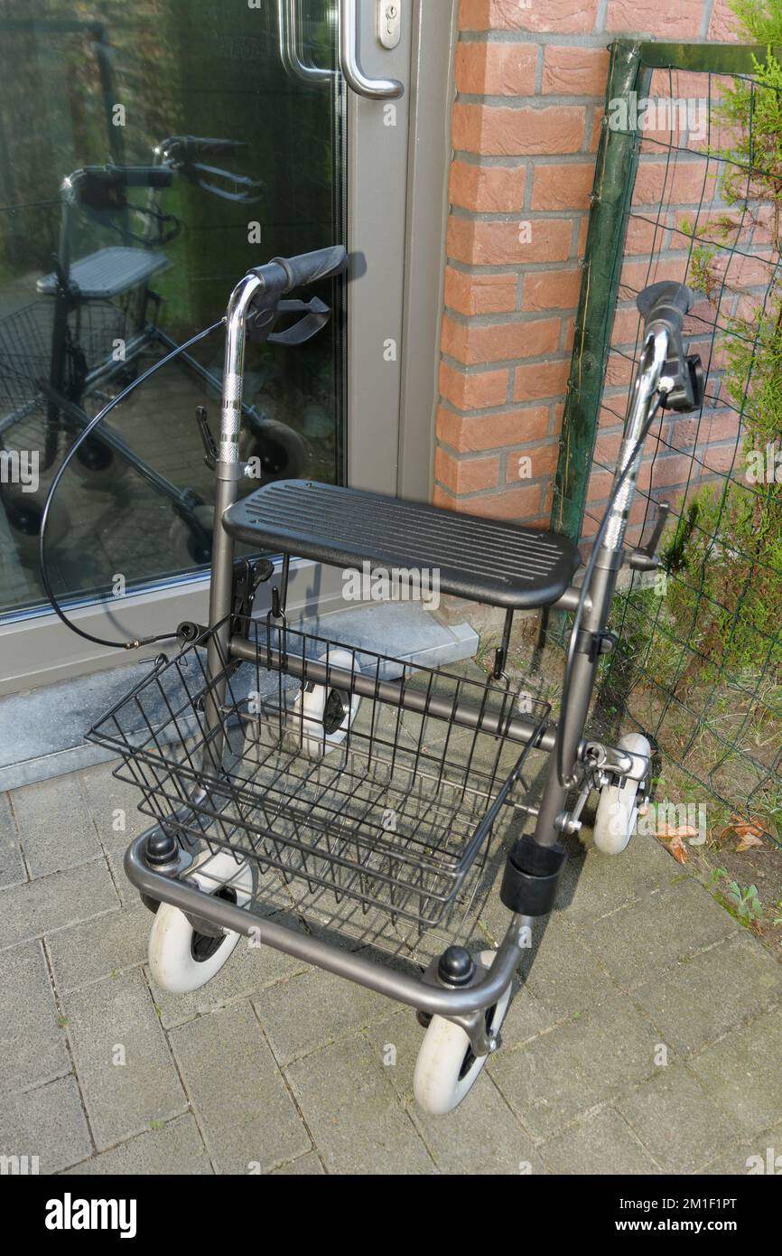 Rollator Walker all'esterno, pronto a fare una passeggiata vicino alla porta d'ingresso della casa Foto Stock