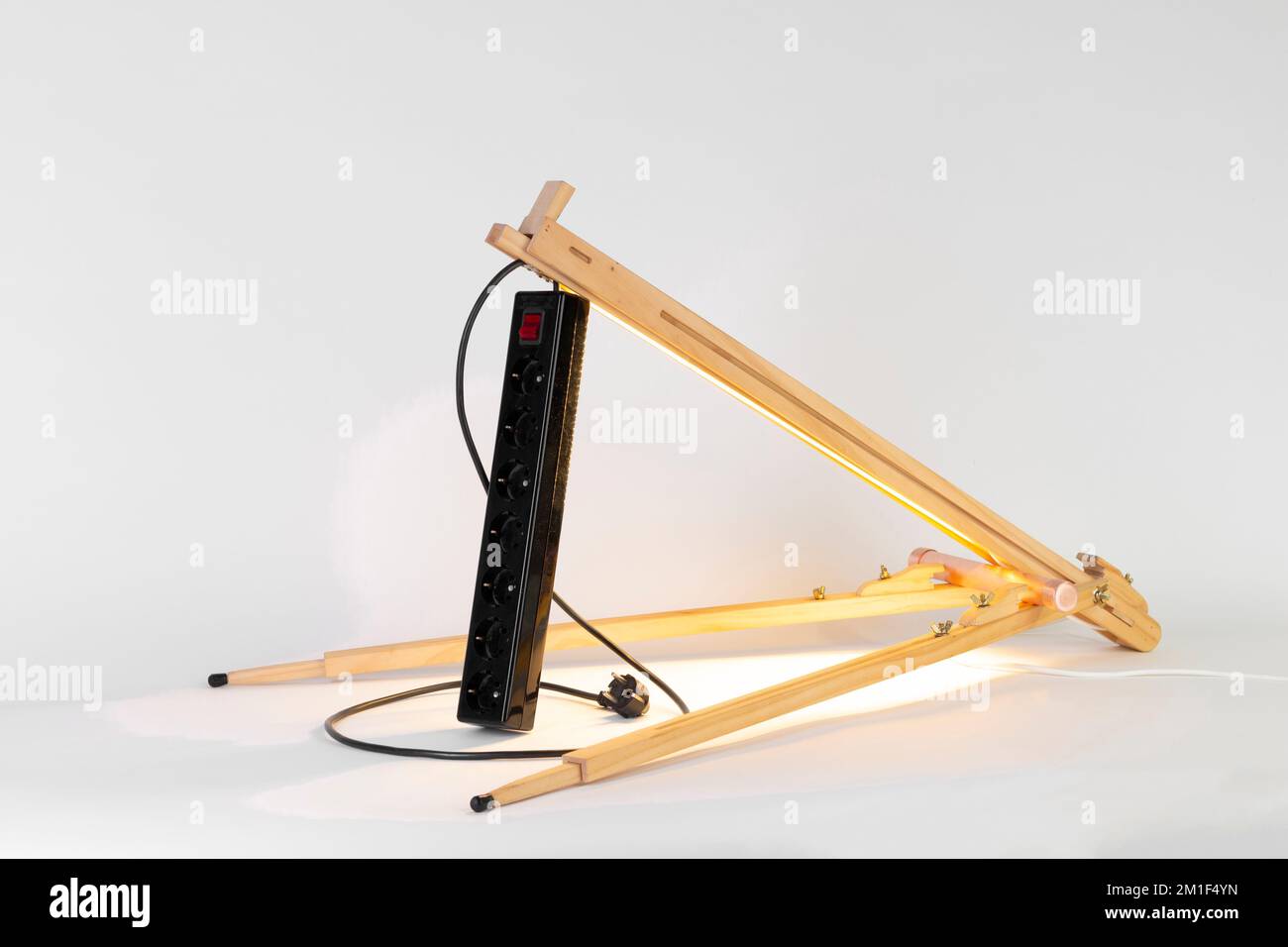 Un primo piano di un blocco di presa nero su un cavalletto di legno su uno sfondo bianco Foto Stock