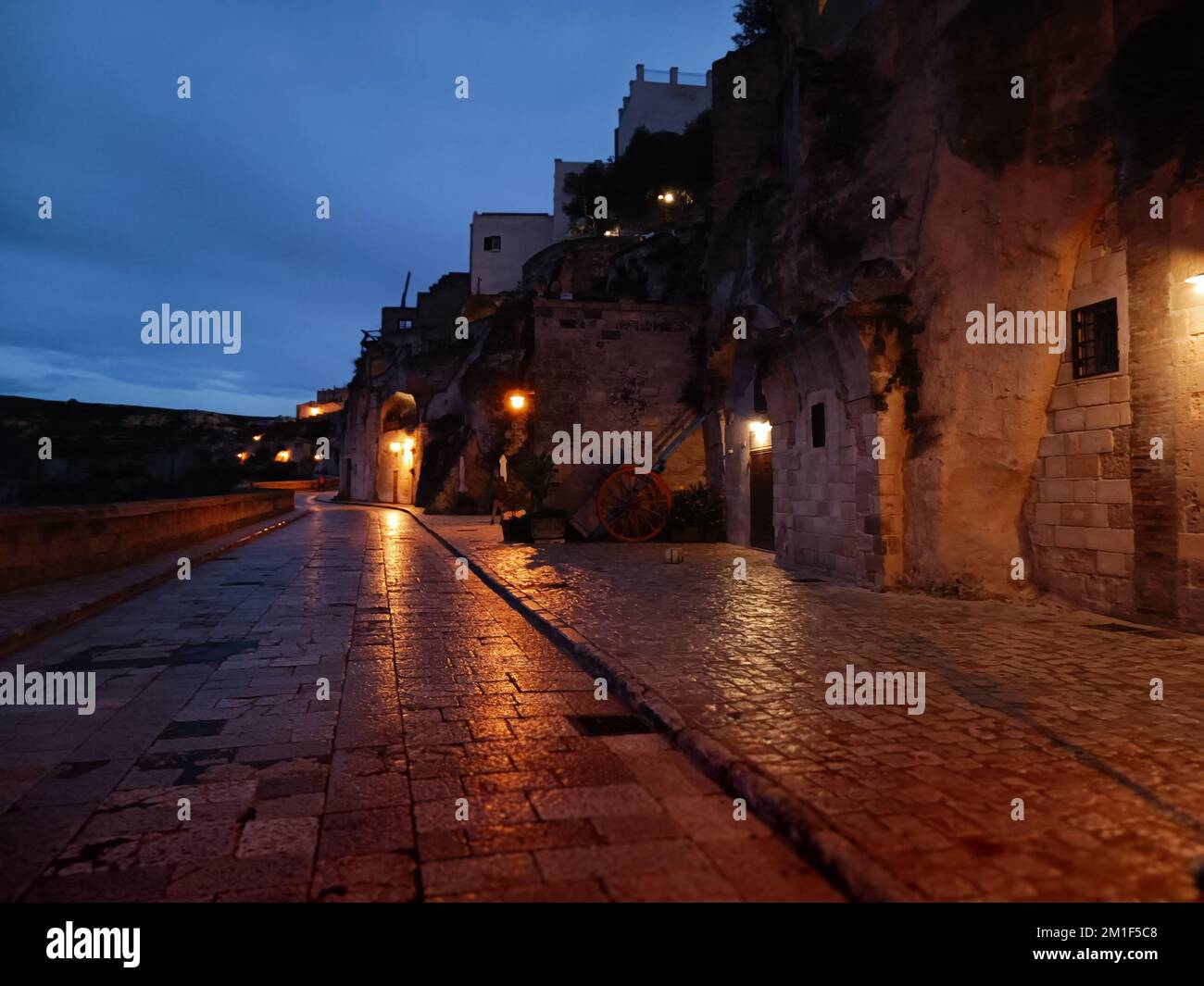 La strada della città Matera con antichi edifici illuminati da lampade di  notte, Italia Foto stock - Alamy