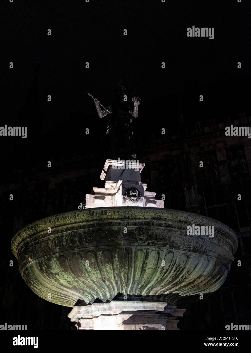 Uno scatto verticale della parte superiore di una fontana di notte. Foto Stock