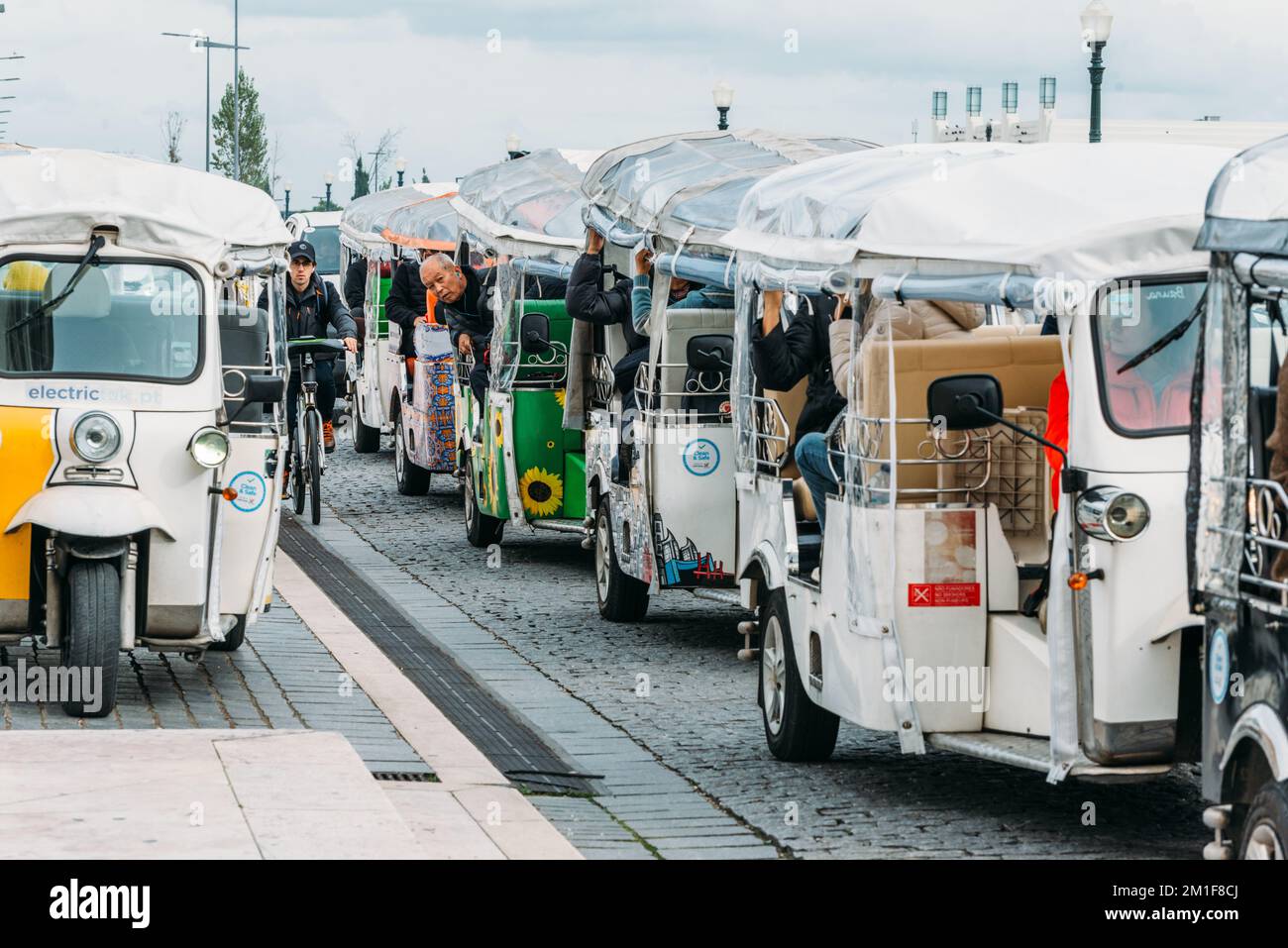 Traffico tuk tuk a Lisbona, Portogallo, con molti turisti in attesa. Si tratta di un mezzo di trasporto popolare in città Foto Stock