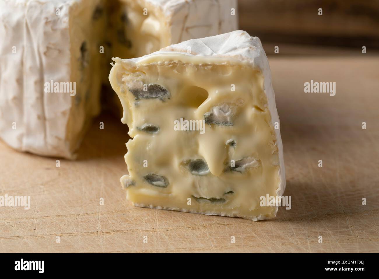 Pezzo di Bresse Bleu francese mature a fette in primo piano su un tagliere Foto Stock