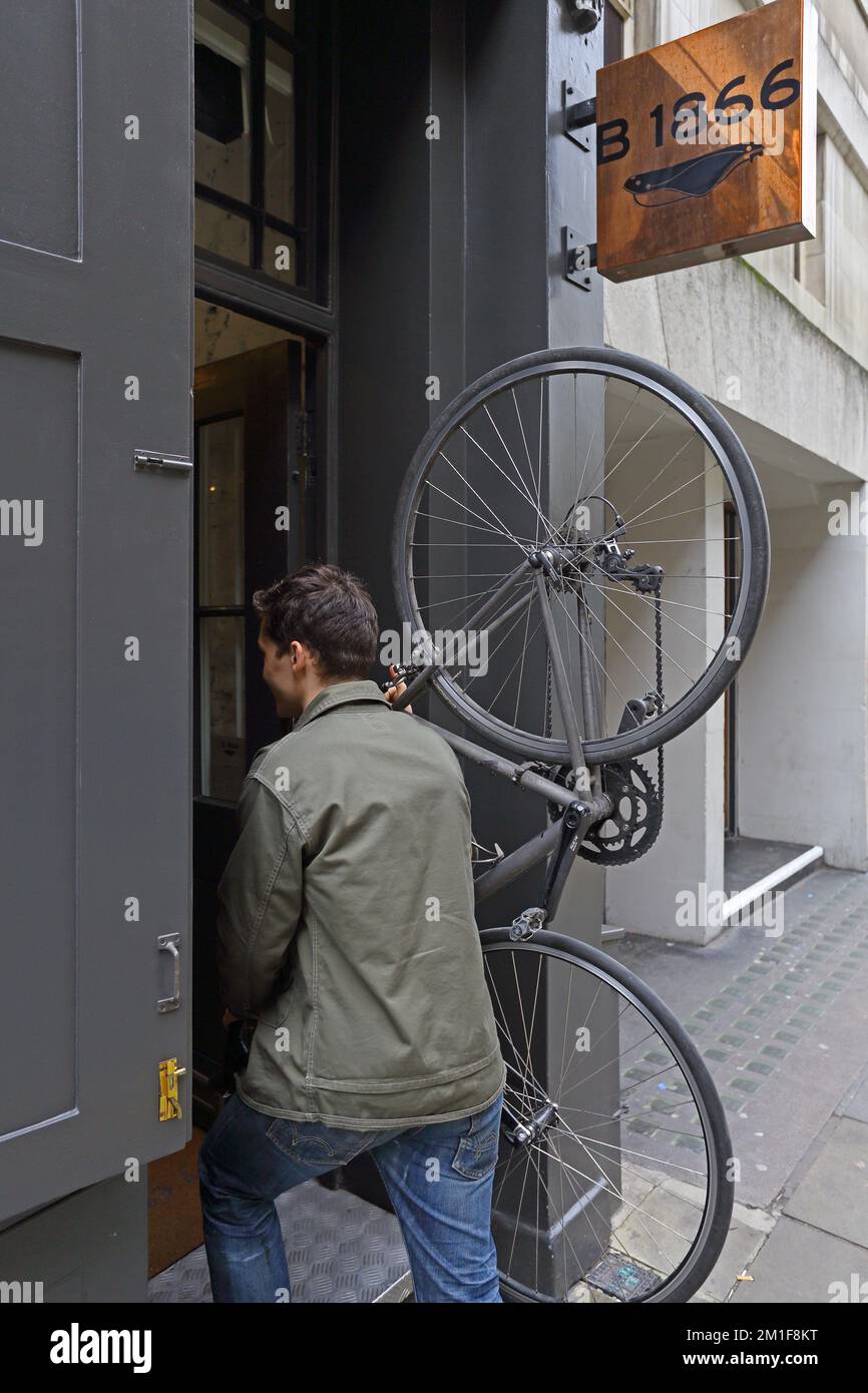 ciclista portare una bicicletta all'interno di un edificio Foto Stock