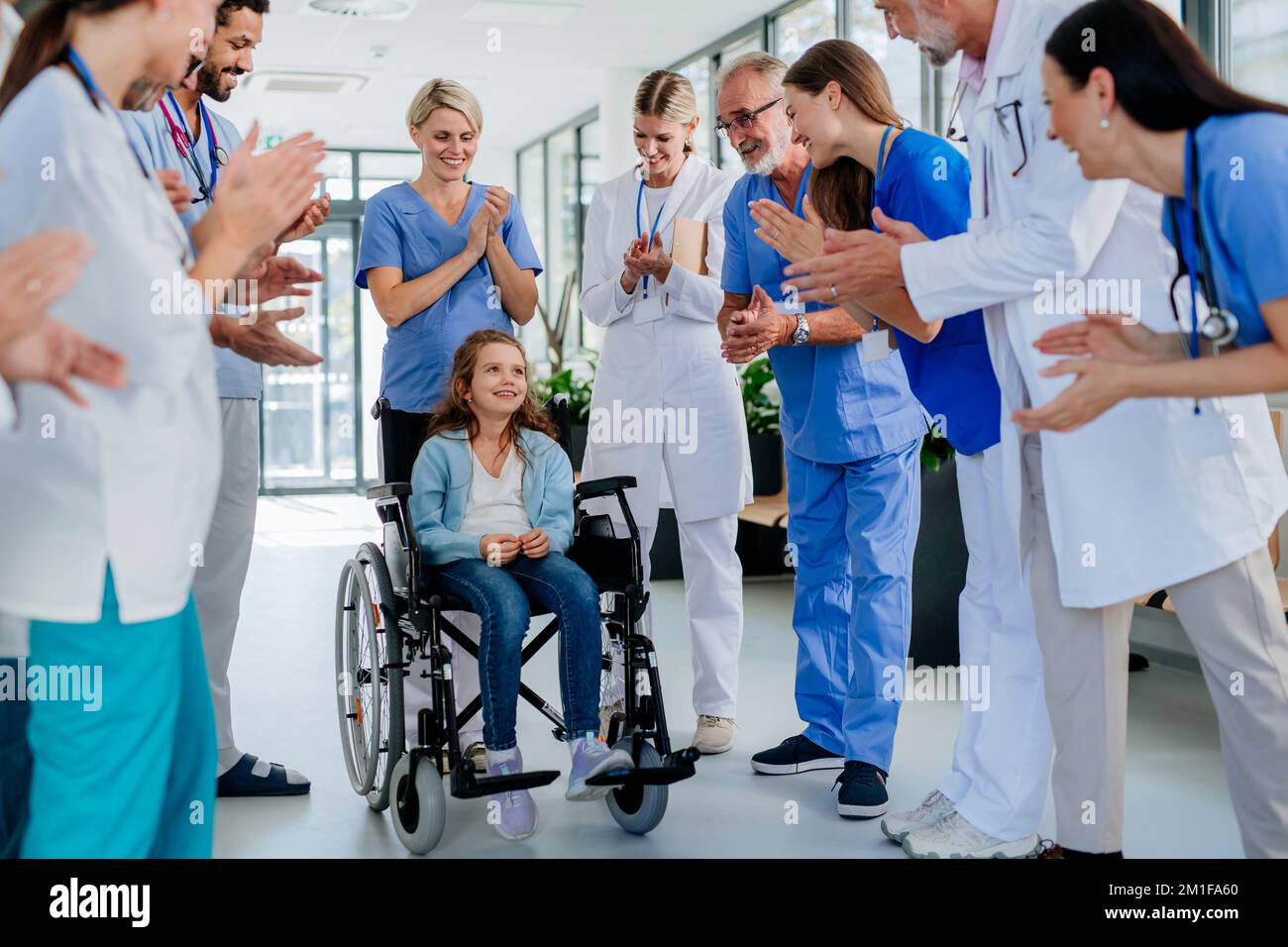 Il personale medico si aggrappa a una bambina che si è ripresa da una grave malattia. Foto Stock