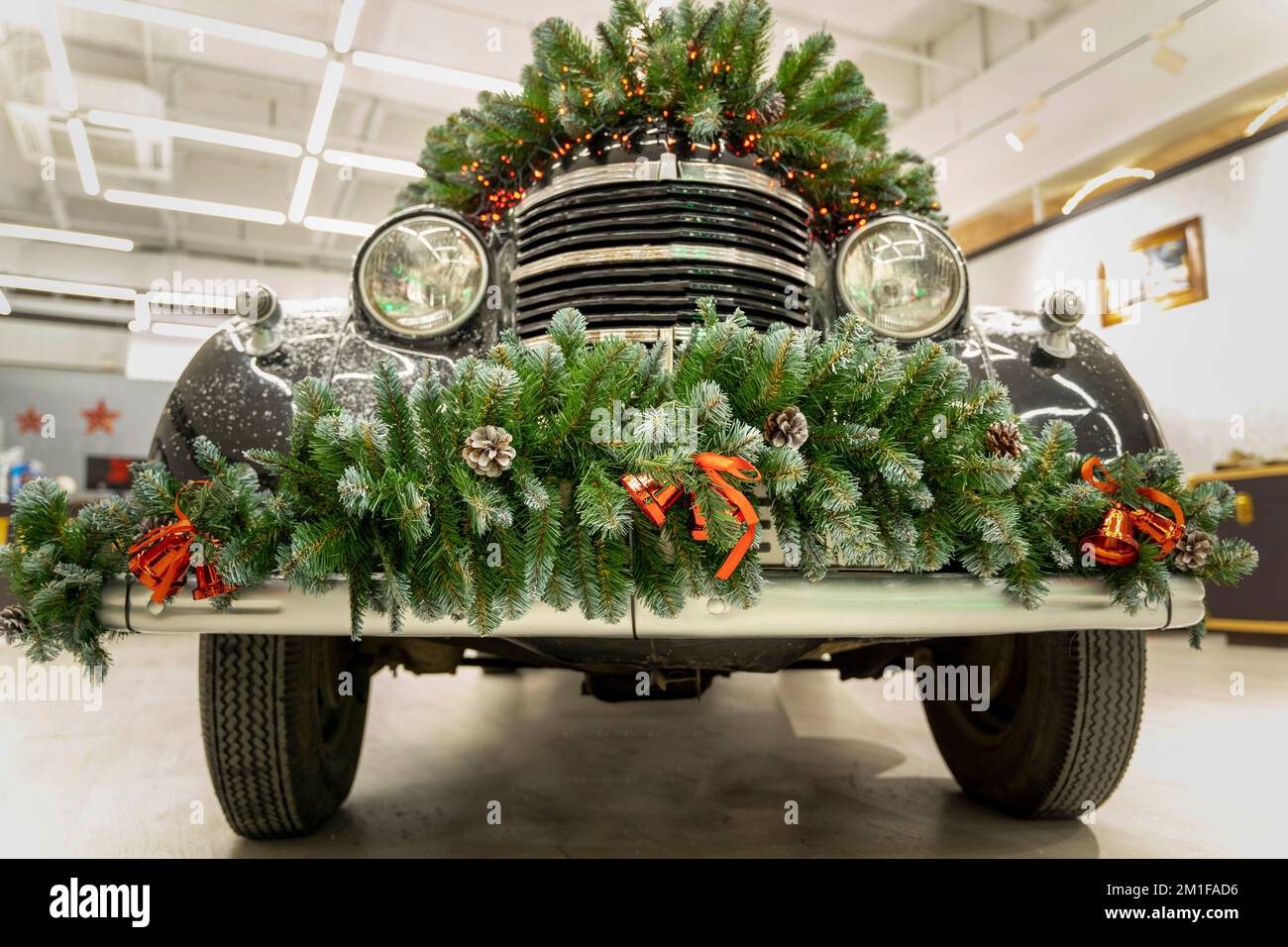 L'auto d'epoca è decorata con rami di abete e decorazioni natalizie Foto Stock