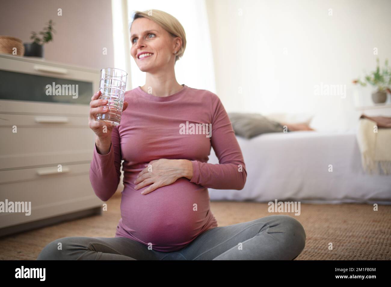 Donna incinta che beve water.Healthy lifestyle e la routine mattutina in gravidanza, concPET. Foto Stock