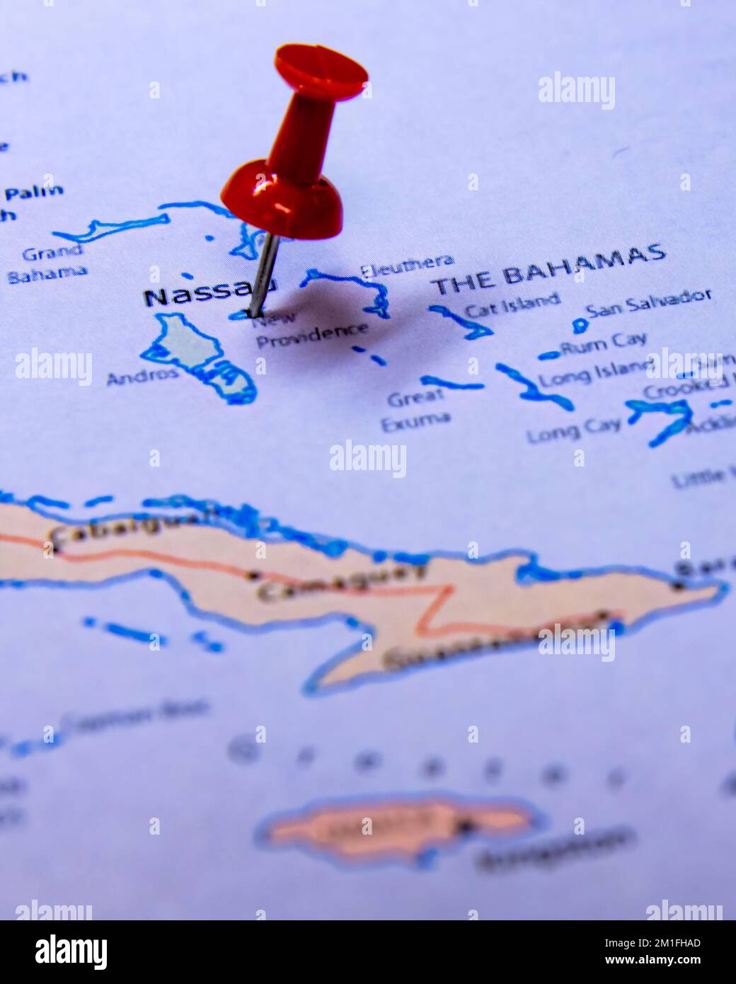 Un primo piano verticale di una puntina rossa in viaggio su una mappa delle Isole Bahamas Foto Stock