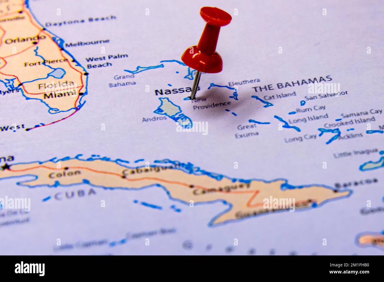 Un primo piano di una puntina rossa in viaggio su una mappa delle isole Bahamas Foto Stock