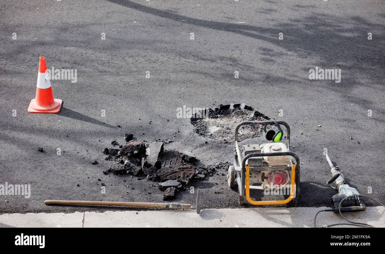 generatore di benzina con utensili per lavori di costruzione su strade e strade urbane, martello perforatore in asfalto in cantiere Foto Stock