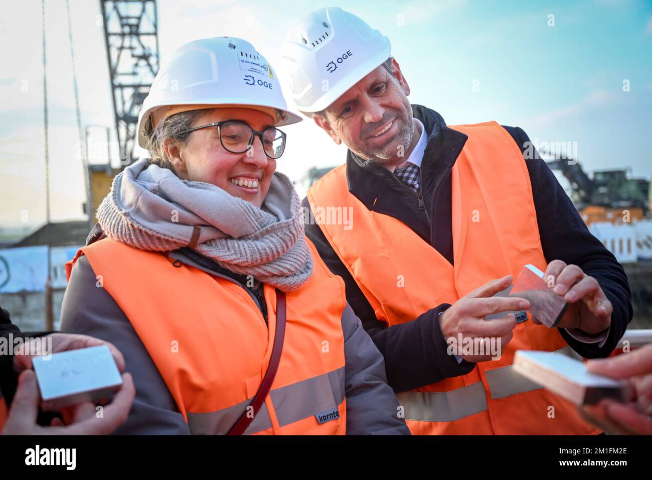 Friedeburg, Germania. 12th Dec, 2022. Le bugie dell'OLAF (SPD, r), ministro dell'Economia e dei Trasporti in bassa Sassonia, e Anka Dobslaw, segretario di Stato per l'ambiente in bassa Sassonia, detengono pezzi del tubo del Nord tedesco gas naturale trasversale (NETRA). Con un ultimo tratto, il nuovo gasdotto per il terminale di importazione di gas naturale liquefatto (GNL) di Wilhelmshaven è stato ora collegato alla rete tedesca di trasporto del gas. In un cantiere edile nel distretto della Frisia Orientale di Wittmund, il tubo è stato posato nel terreno e le saldature finali sono state lavorate. Credit: Sina Schuldt/dpa/Alamy Live News Foto Stock