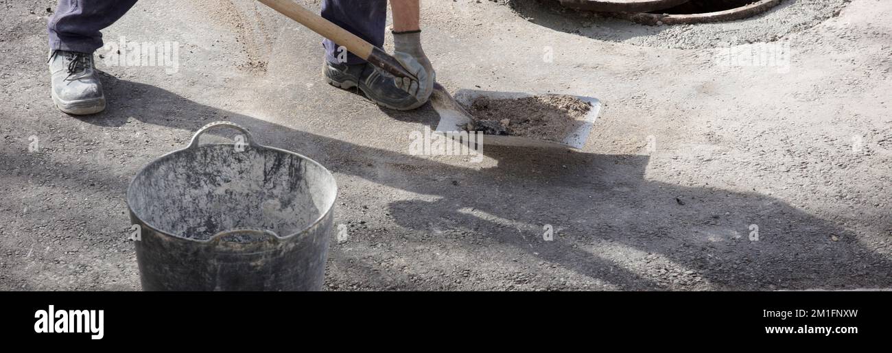 operatore in finitura uniforme processo di pulizia con una pala elettrica, registra la strada urbana su asfalto Foto Stock