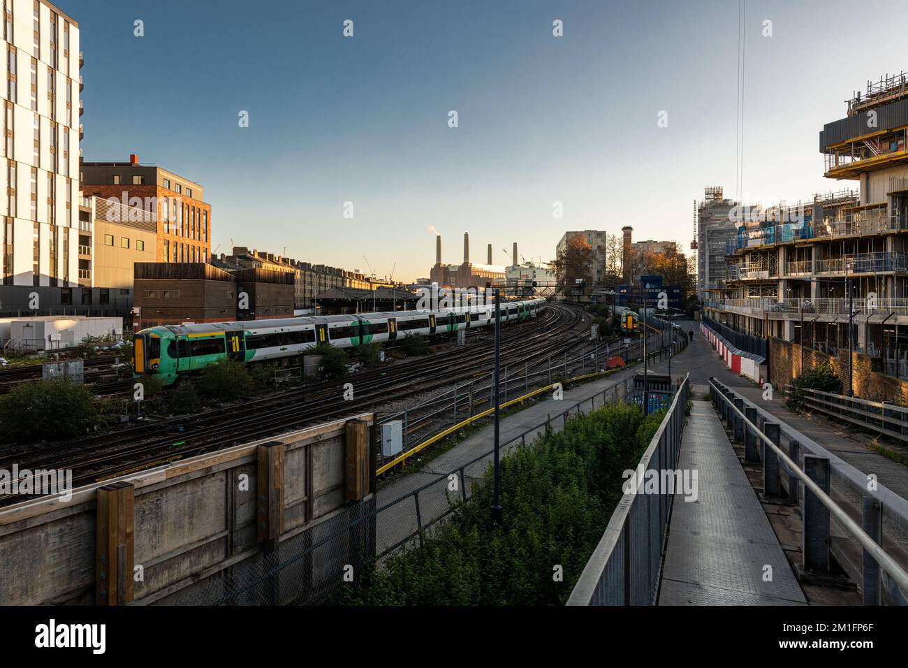 Un treno arriva alla stazione Victoria, una centrale di Battersea recentemente rinnovata può essere vista in lontananza.Londra Dic 2022. Foto Stock