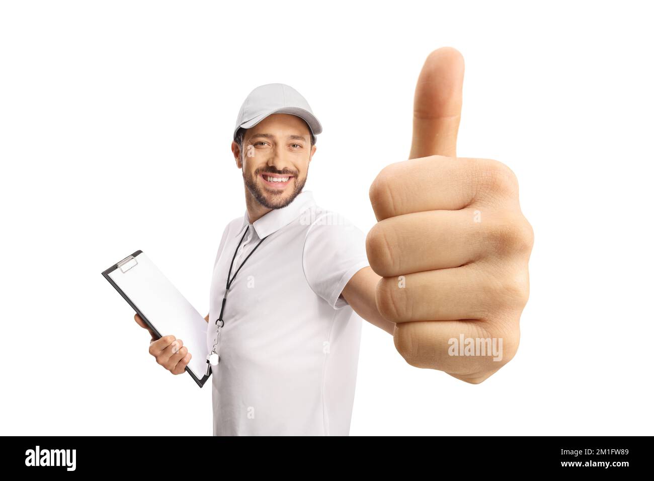 Allenatore sportivo con un fischio che tiene un clipboard e mostra i pollici isolati su sfondo bianco Foto Stock