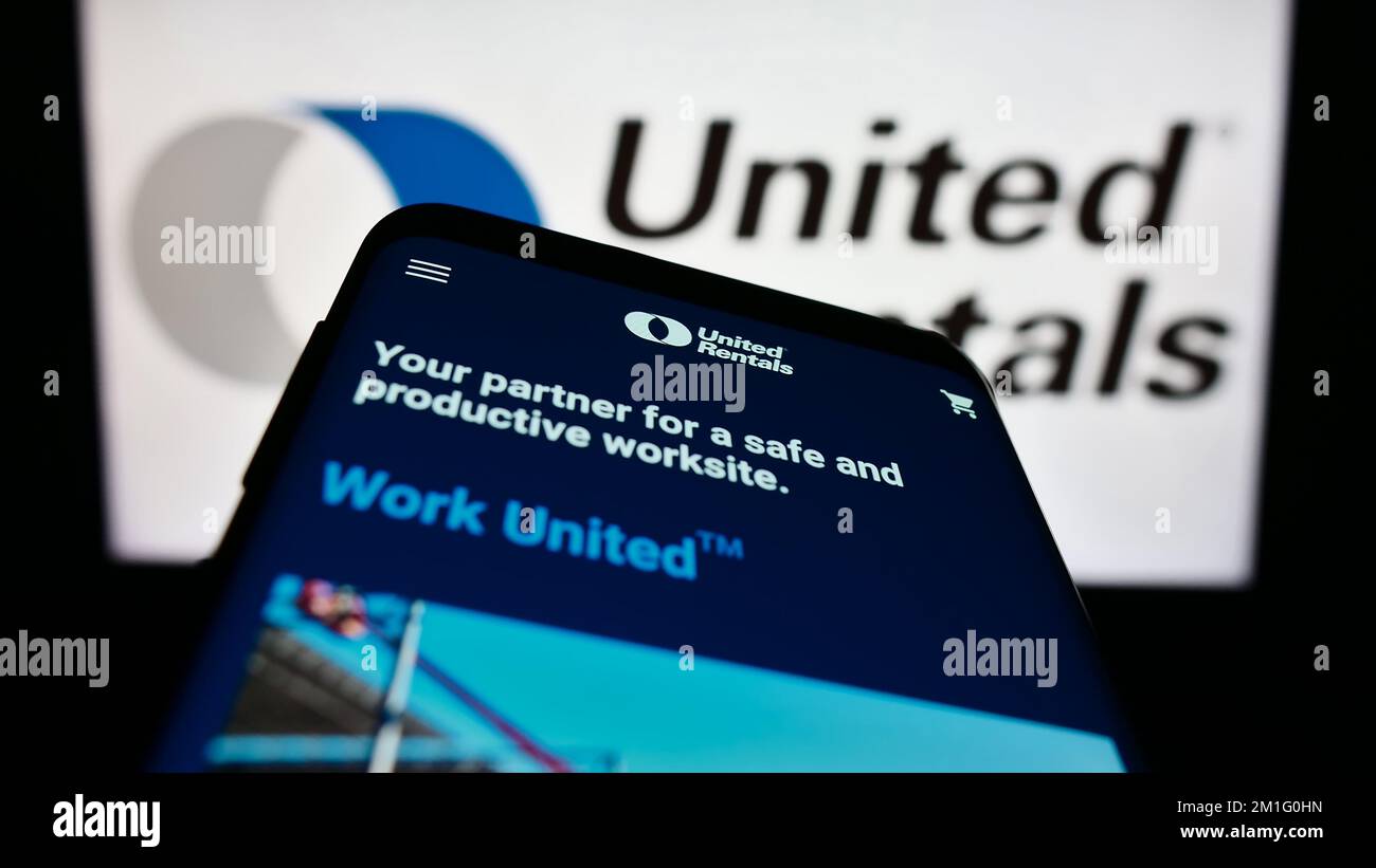 Smartphone con sito Web della società di noleggio attrezzature USA United Rentals Inc. Sullo schermo di fronte al logo. Messa a fuoco in alto a sinistra del display del telefono. Foto Stock