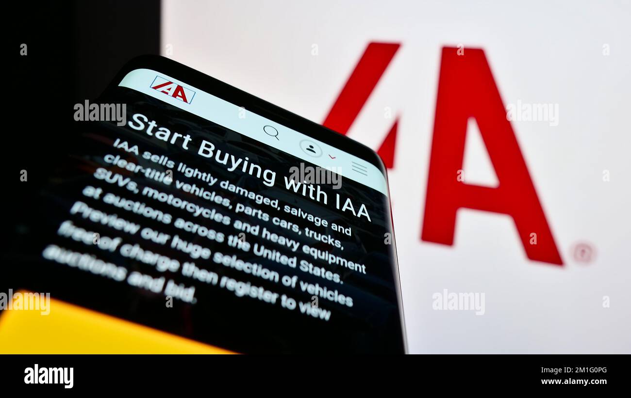 Telefono cellulare con sito web della società di mercato auto USA IAA Inc. Sullo schermo di fronte al logo aziendale. Messa a fuoco in alto a sinistra del display del telefono. Foto Stock