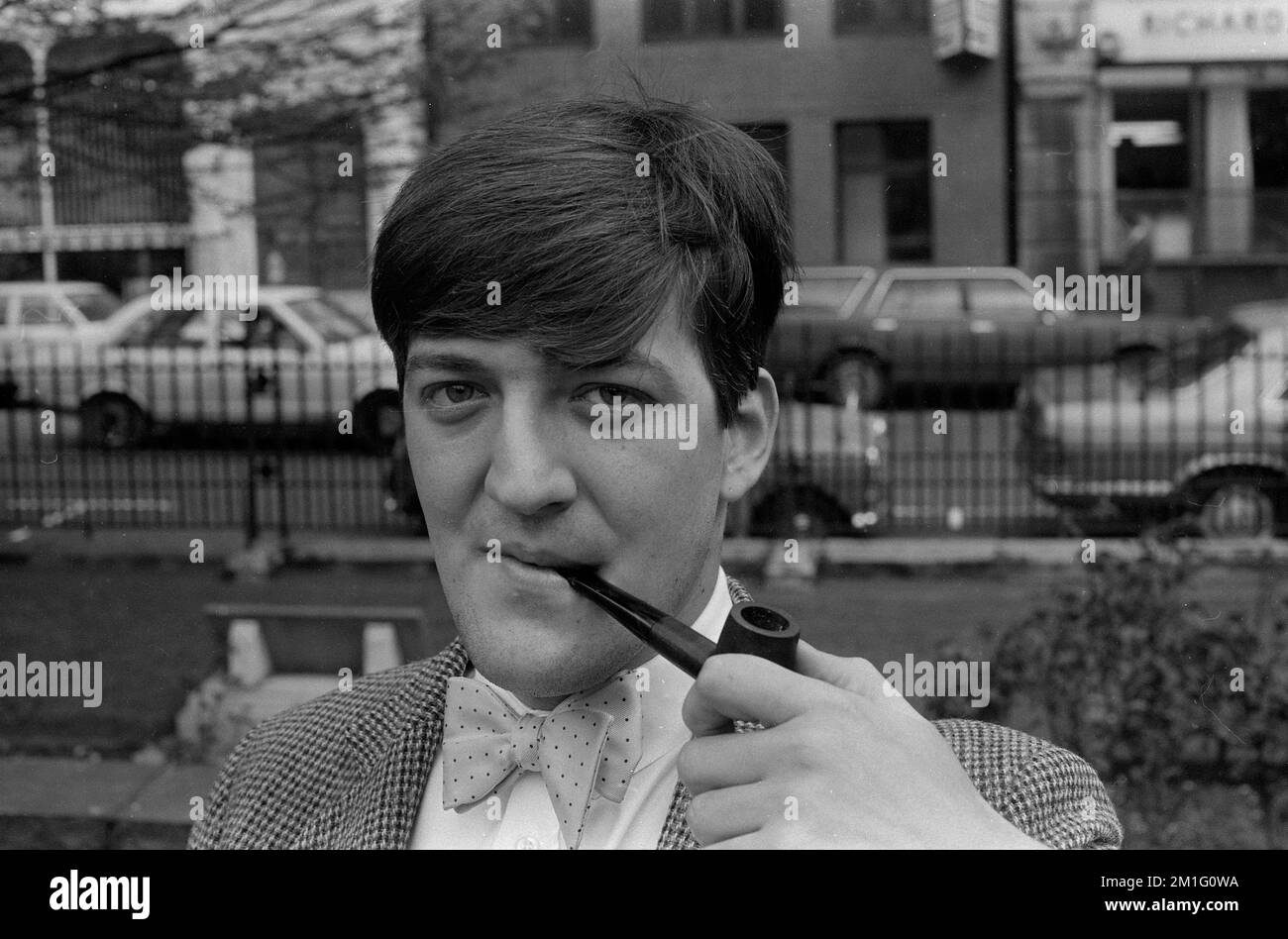 Stephen Fry attore inglese, emittente televisiva, comico, Stephen Fry fumando una pipa nel 1983 Foto Stock