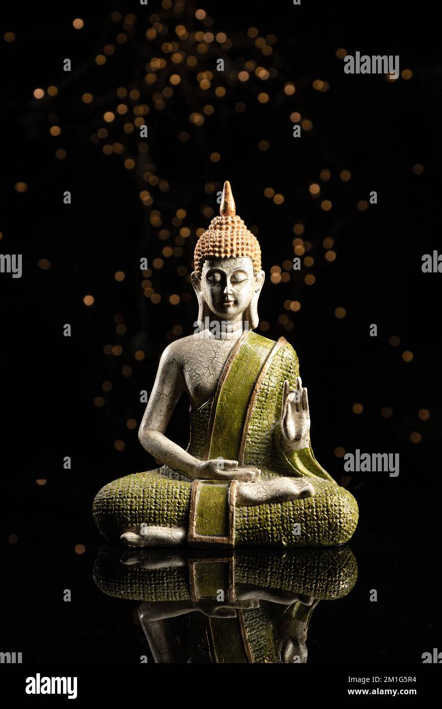 Statua di Buddha in meditazione su sfondo nero. Formato verticale. Foto Stock