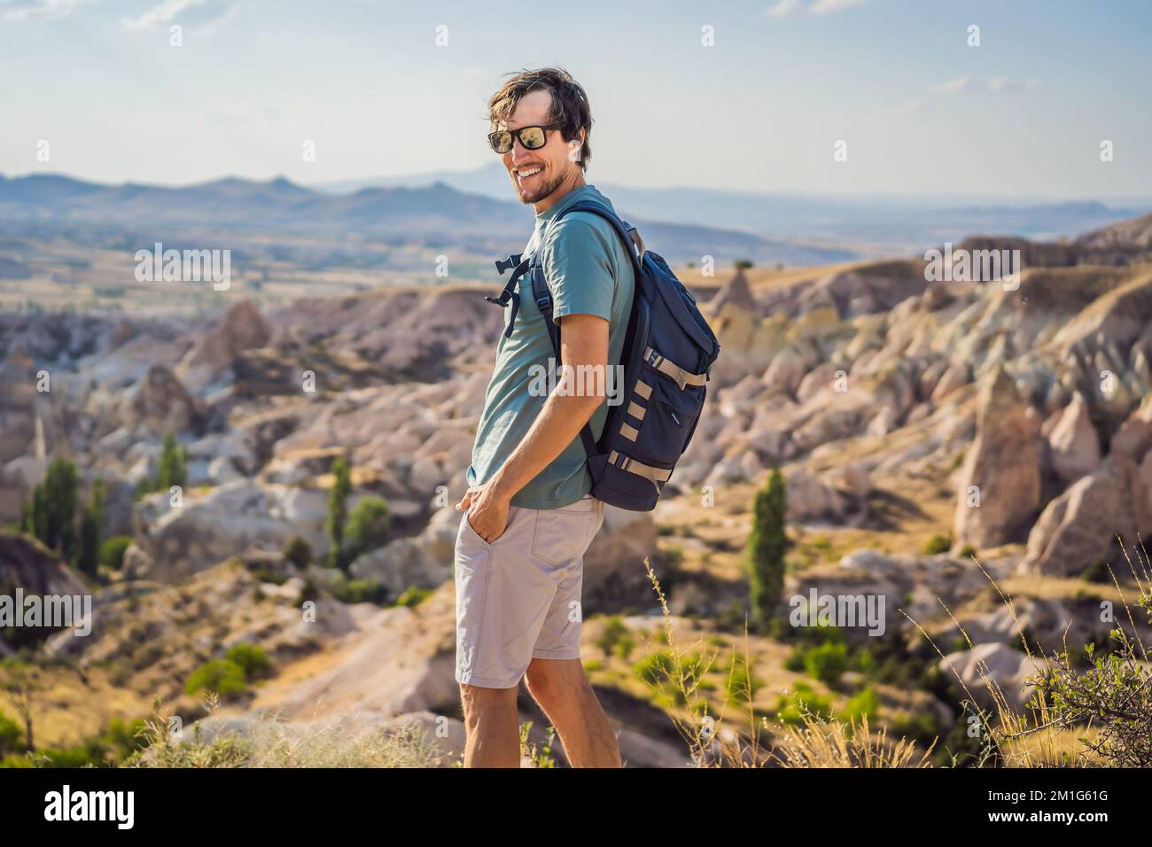 Giovane esploratore valle con formazioni rocciose e grotte delle fate vicino a Goreme in Cappadocia Turchia Foto Stock