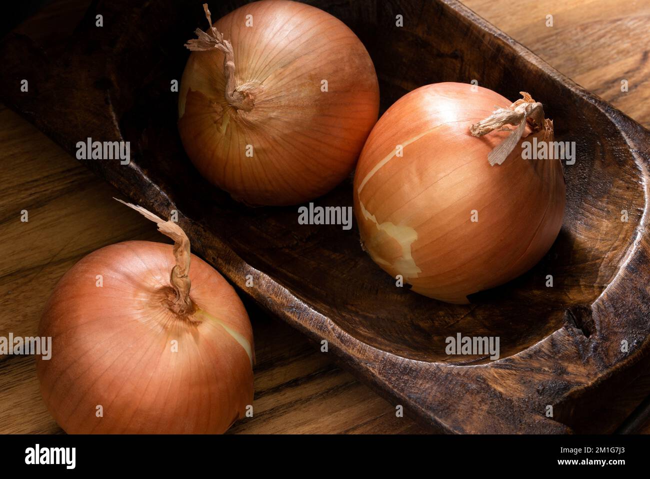Cipolle intere in una ciotola di legno Foto Stock