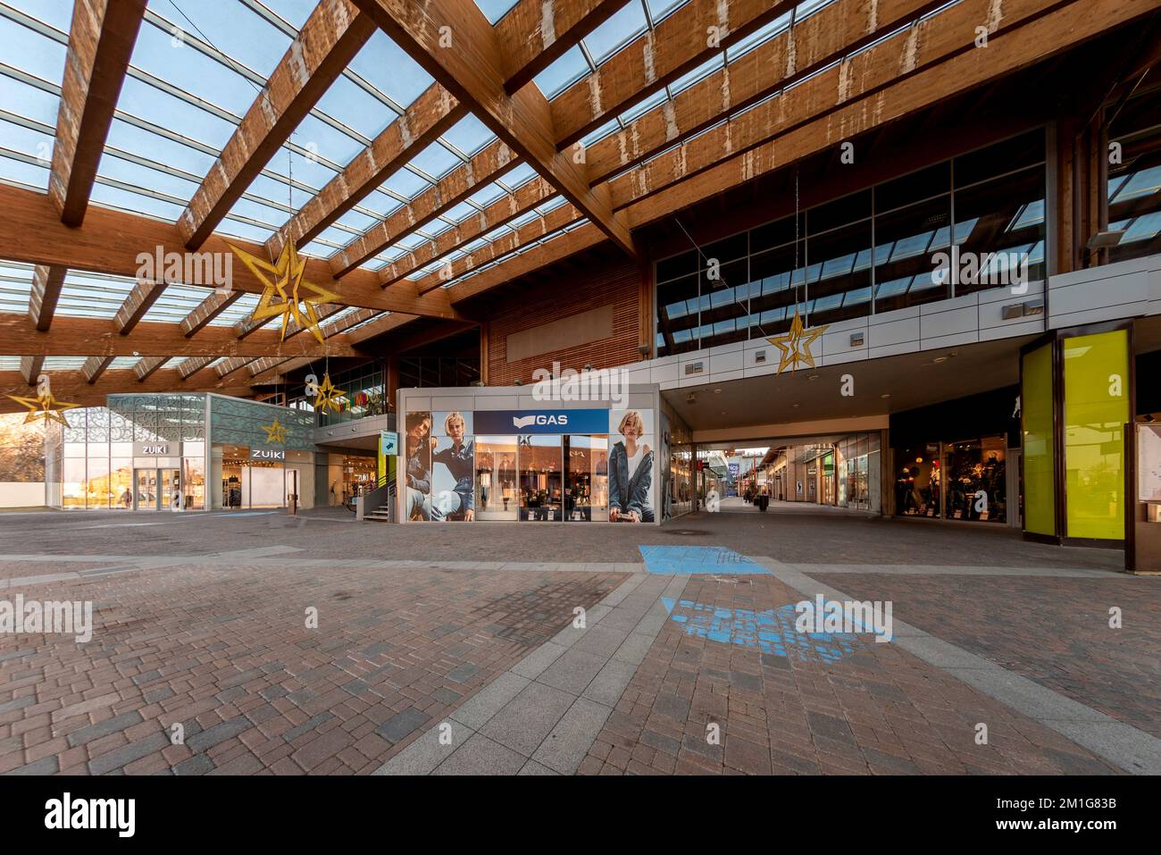 Mondovì, Italia - 07 dicembre 2022: Veduta stradale dell'architettura interna del borgo outlet di Mondovicino con negozi e marchi famosi, gas Store Foto Stock