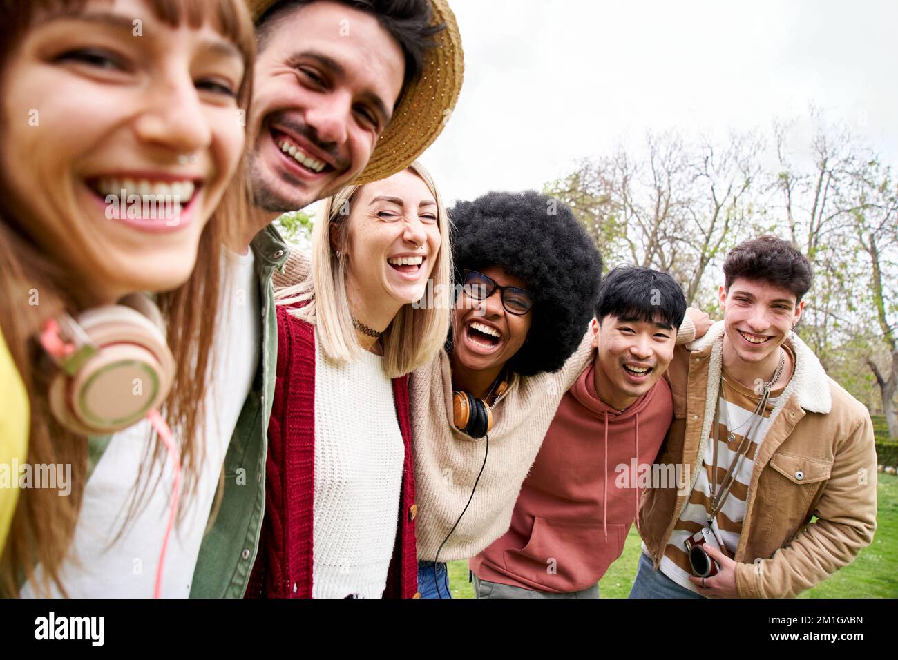 Ritratto di gruppo di corse miste di amici sorridenti che guardano la telecamera. I giovani studenti prendono un selfie Foto Stock
