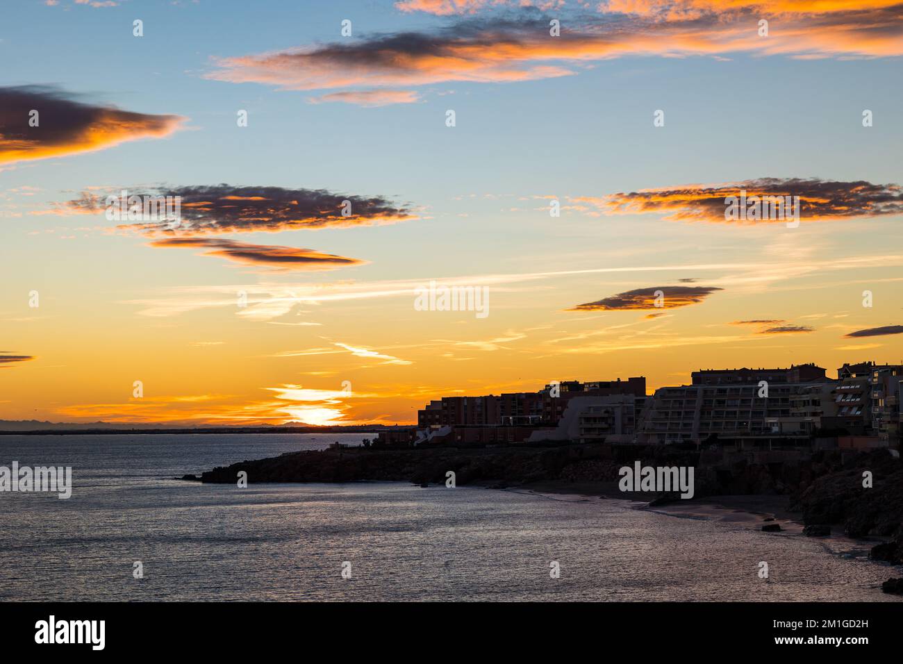 Ciel rougeoyant au coucher du soleil sur la Cirque de l'Anau et la Mer Méditerranée à Sète Foto Stock
