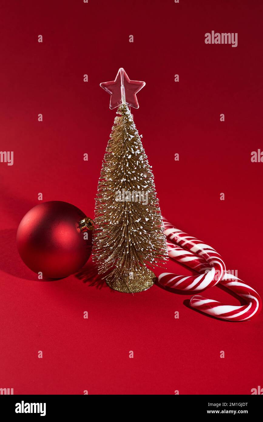 Banner con decorazioni natalizie su sfondo rosso con piccolo albero di natale Foto Stock