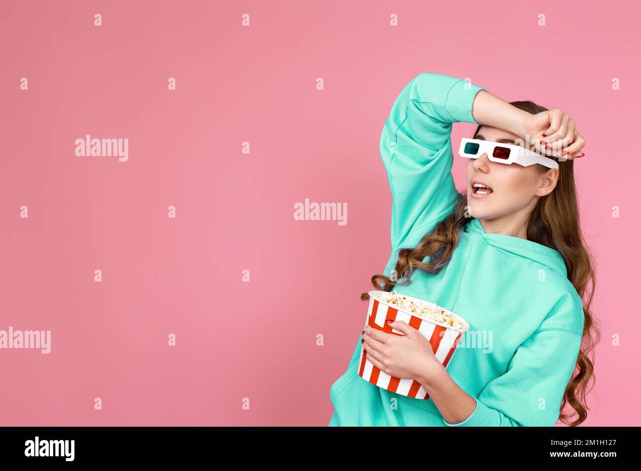 donna in felpa con secchio di popcorn Foto Stock