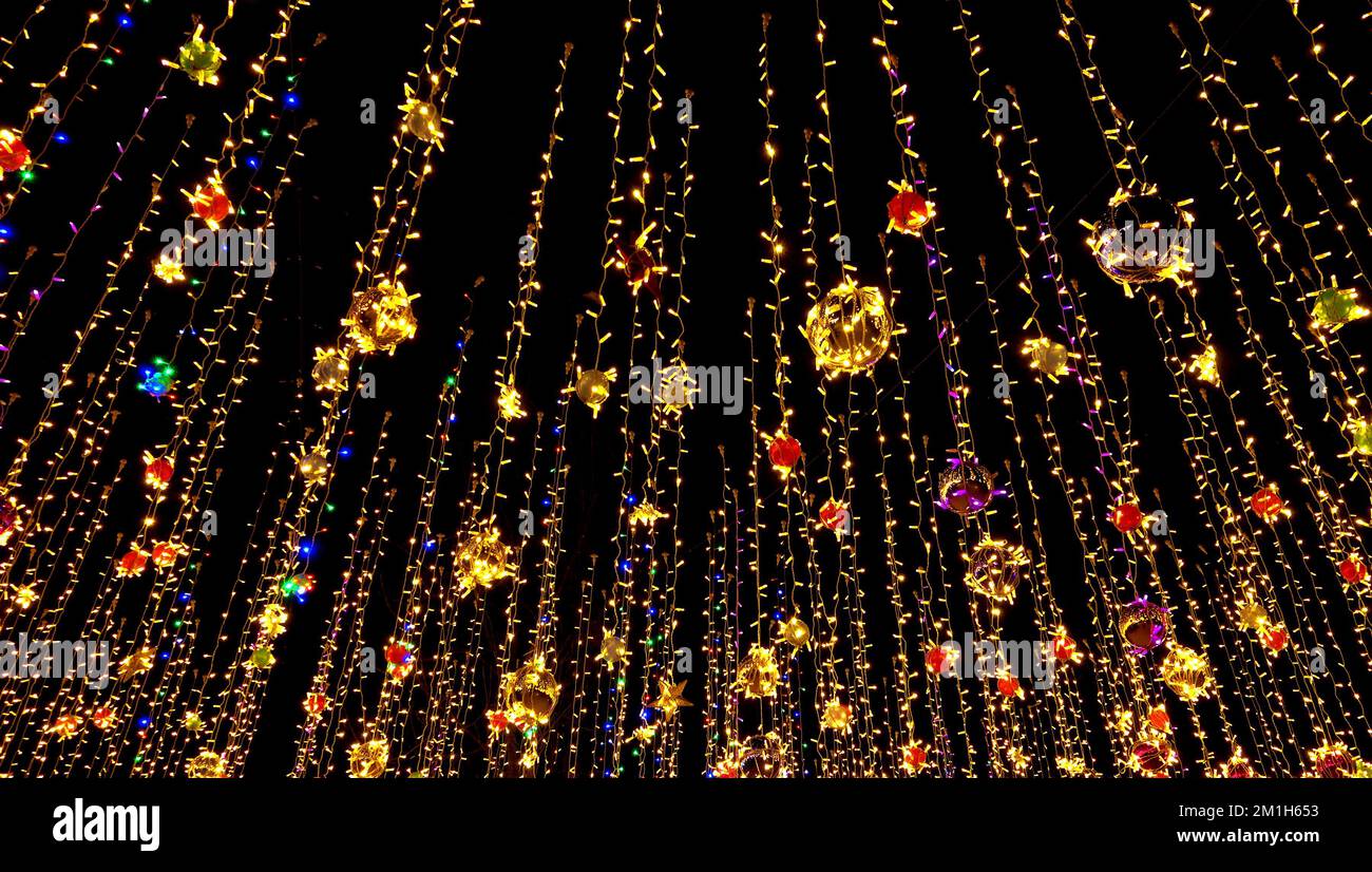 Decorazioni di nuovo anno, ghirlande colorate nel cielo notturno Foto Stock