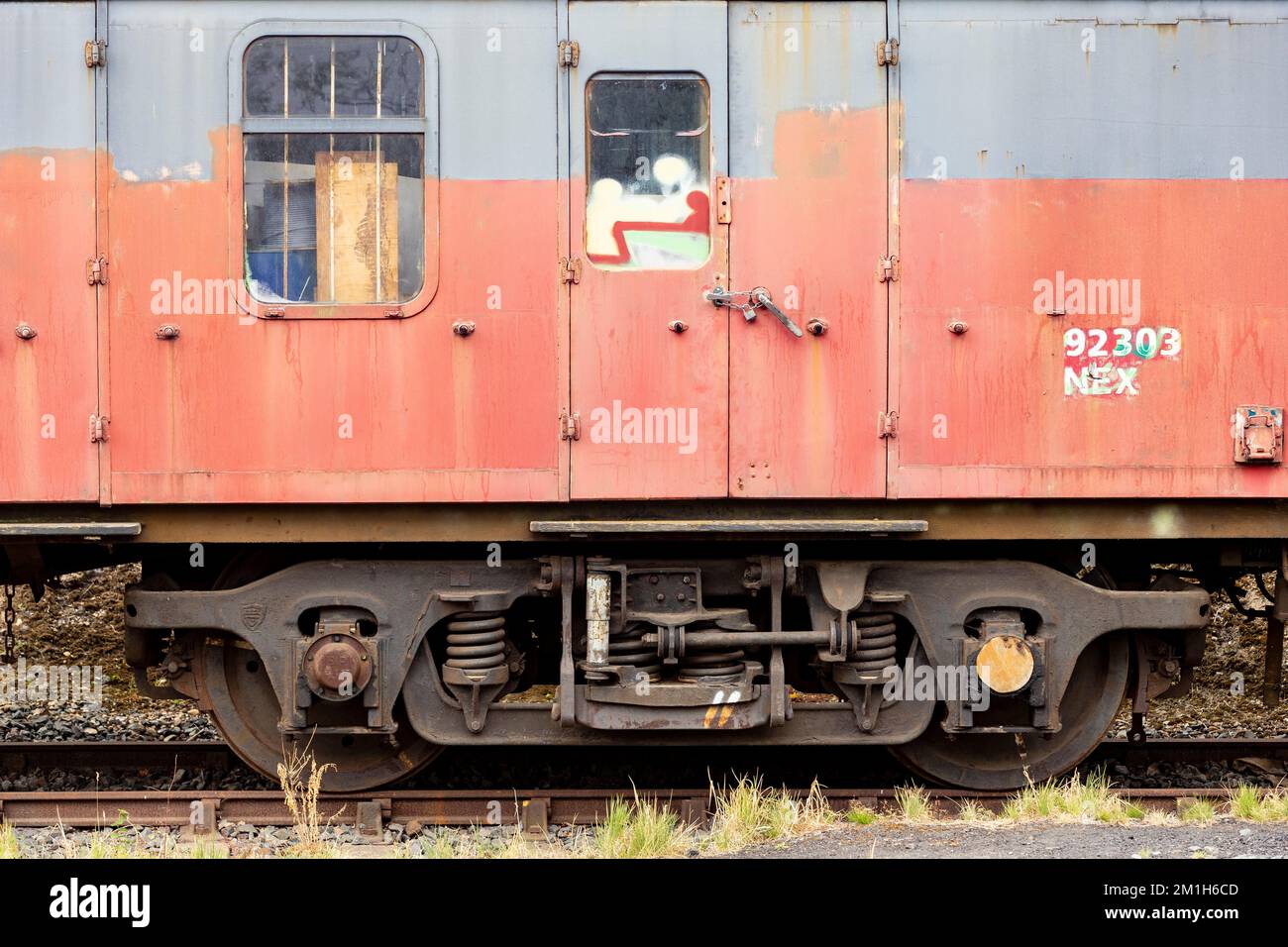 Un vecchio vagone ferroviario passeggeri con vernice di pelatura sul carro ferroviario. Foto Stock