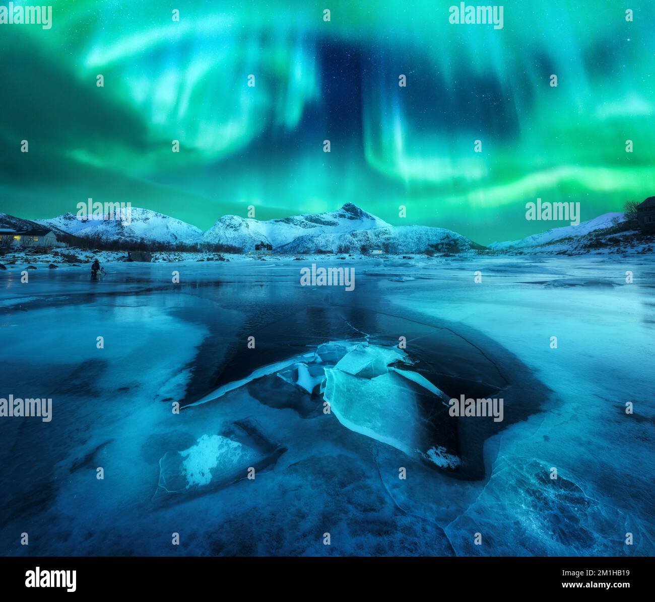 Northern Lights su montagne innevate, surgelate costa del mare Foto Stock