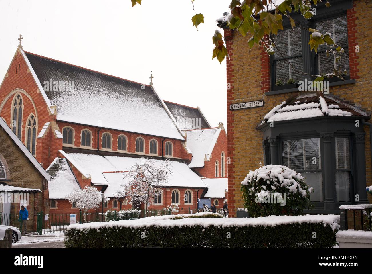 Inverno in un sobborgo di Londra: Verde strada in Abbey Wood, sud-est di Londra. La chiesa è San Michele e tutti gli Angeli Foto Stock