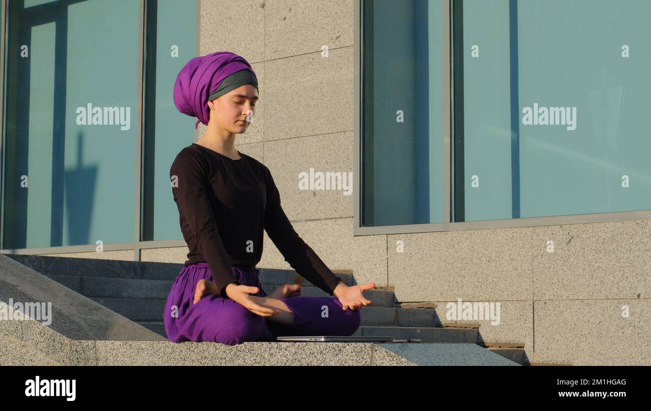 Stanca preoccupata ragazza islamica sovraccarica studentessa musulmana uomo d'affari seduto in città che studia al laptop si sente arrabbiato spegne il computer si siede dentro Foto Stock