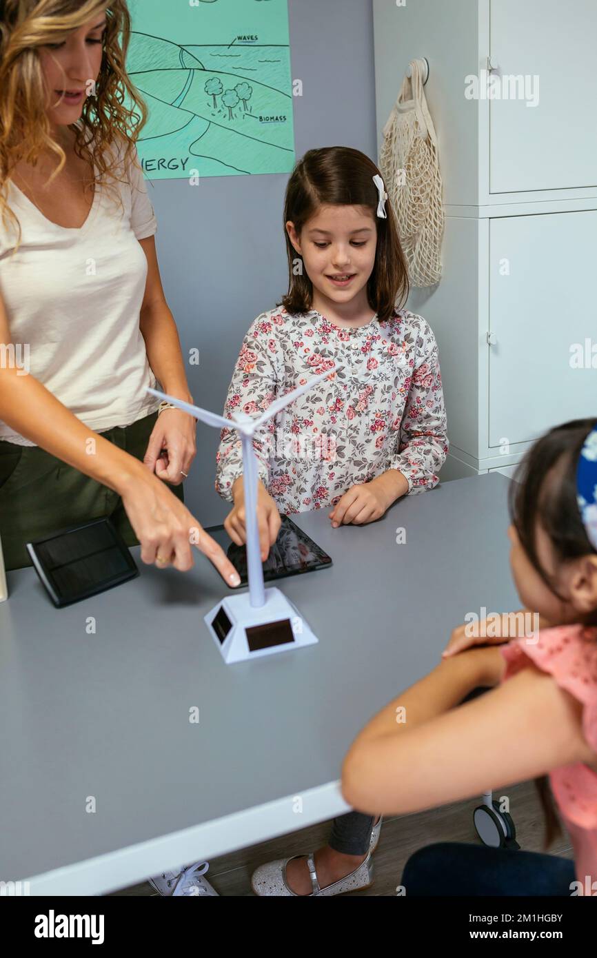Studente che mostra mulino a vento solare per classe in classe ecologia classe Foto Stock