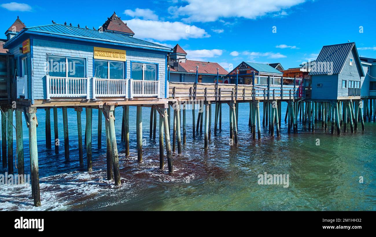 Vecchio molo di legno coperto in edifici sulla costa del Maine dell'oceano Foto Stock