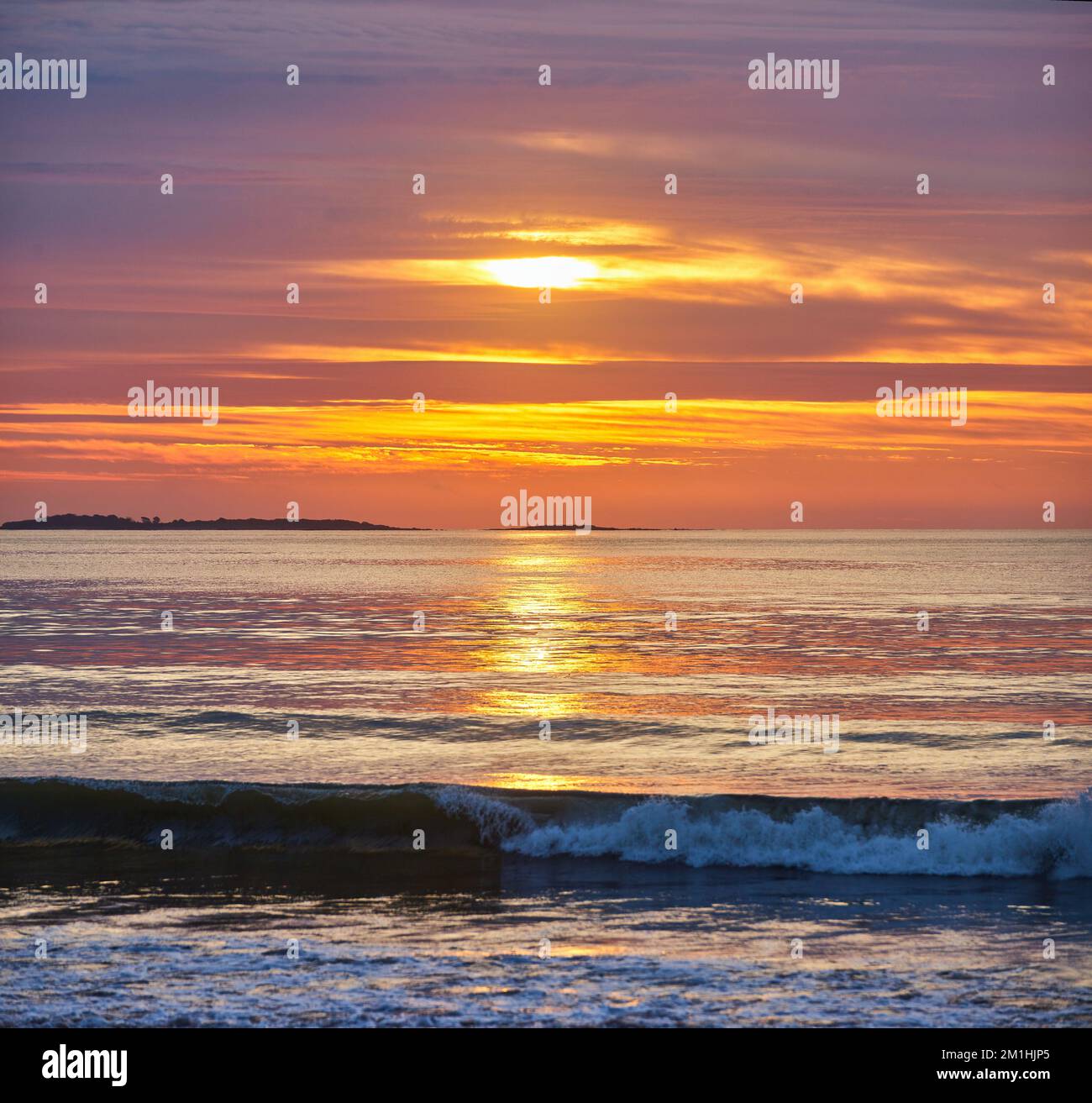 Splendida alba sull'oceano della costa orientale con onde che si infrangono Foto Stock